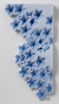 A wall hanging sculpture of blue flowers on a white rectangle