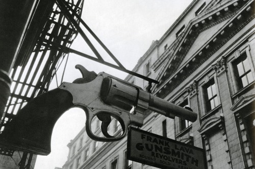 A black and white image of a sign in the shape of a gun