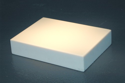 A white rectangular prism sits on dark ground and slightly glows