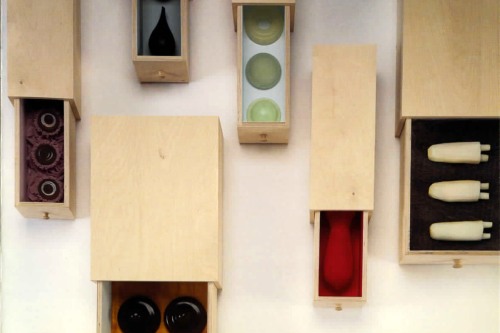 Slightly open wooden boxes holding "memory objects"