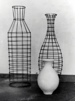 Three vases, one of white clay and others made of a wire scaffold