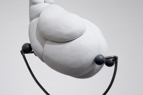 Sculpture of large white blobs connected and resting upon a thin metal structure