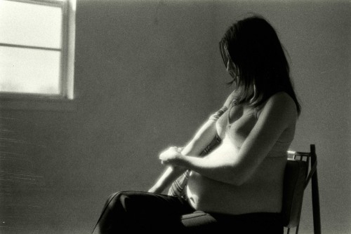 Black and white photograph of a pregnant woman participating in drug use
