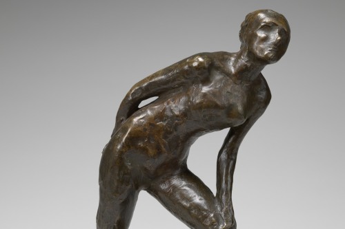 Bronze sculpture of a human figure leaning on its left knee