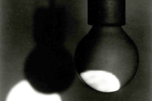 Photograph of a round white light partially projected onto a lightbulb