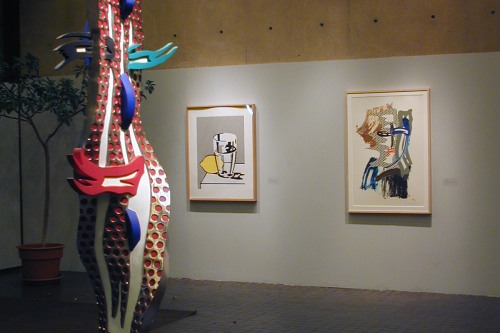 Photograph of a sculpture and two paintings inside the lobby of the List Art Center